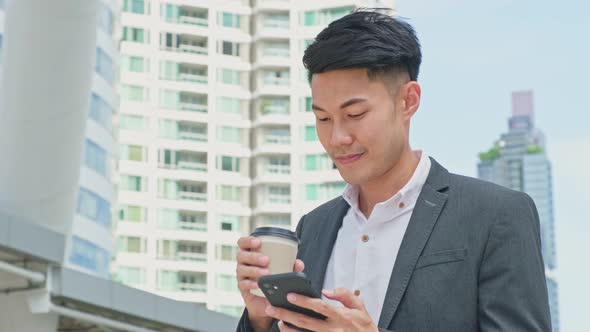 Asian young smart business man use mobile phone chat and communicate with co worker in city.