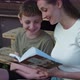 Mother Reads a Book with Her Son Sitting on the Steps - VideoHive Item for Sale