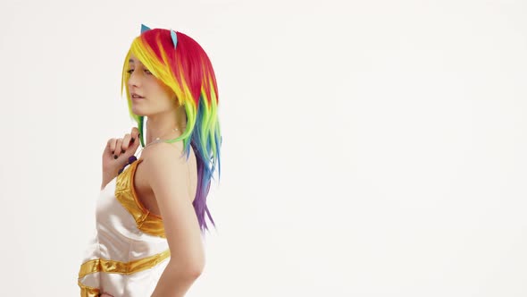 Young Woman with Rainbow Hair Turns and Looks Kindly Into the Camera Medium Studio Shot White