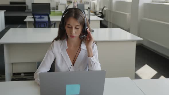 Serious Young Worker Sits and Speaks to the Customer