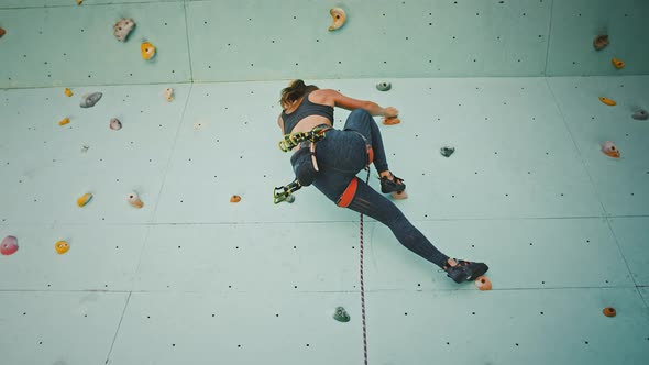 Tracking Shot of Sporty Woman Climber Practicing at Outdoor Gym Rock Below View