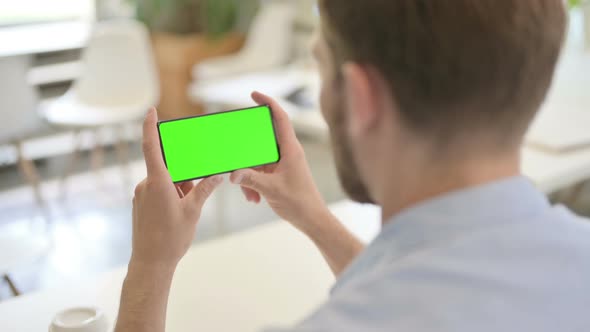Young Creative Man Looking at Smartphone with Chroma Screen