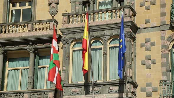 Flags of EU, Spain and Basque Country Waving on Government Building Facade