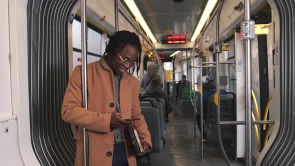 African American Guy in Cadual Clothes Use Phone in Public Transport