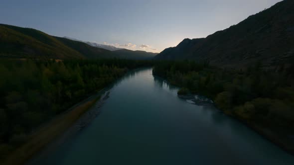 Aerial View Darkness River Water Surface Stones and Grass Forest Trees and Mountain Valley Sunset