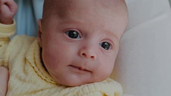 A Cute 2 Month Old Baby Face Lying on Bed