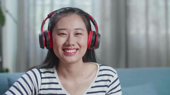Close Up Of Woman Composer With Headphones Looking And Smiling To Camera While Playing Guitar