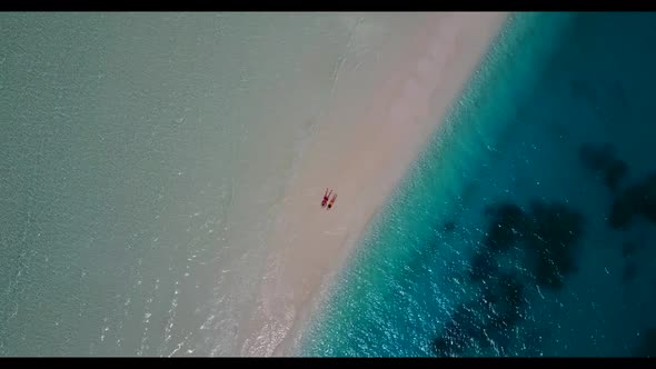 Romantic couple sunbathe on marine coastline beach lifestyle by aqua blue ocean with clean sandy bac