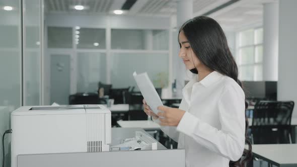 Arab Hispanic Businesswoman Girl Worker Secretary Makes Copies on Photocopier Use Office Equipment