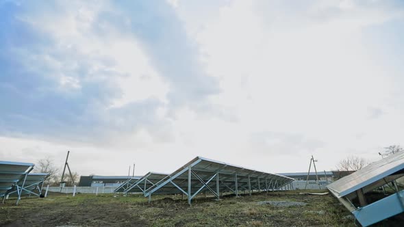 Solar energy farm on the field. Solar panels attached on metal basis on the ground. Renewable source