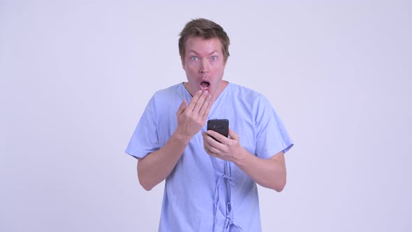 Portrait of Young Man Patient Using Phone and Looking Shocked