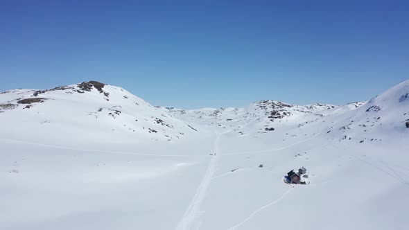 Ski trails with unrecognisable persons in Krossdalen snowy wilderness - Hardangervidda Norway revers