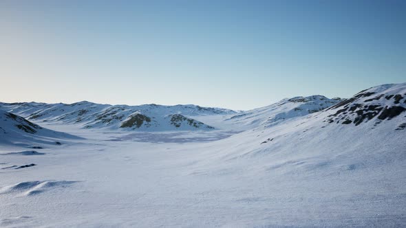 Aerial Landscape of Snowy Mountains and Icy Shores in Antarctica