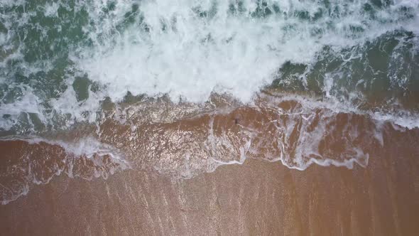 Top view amazing waves crashing on sandy shore. beautiful sea surface in phuket thailand