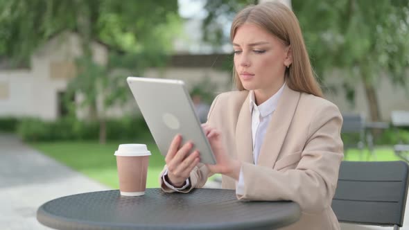 Successful Young Businesswoman Celebrating on Tablet in Outdoor Cafe