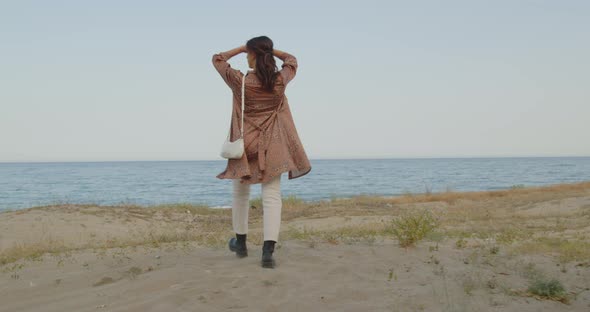 Young girl with black boots has fun on the beach near the sea in Italy