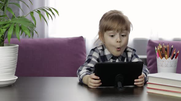 Girl Doing Lessons at Home Using Digital Tablet Computer. Distance Education