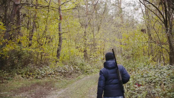 Man shooting gun in forest.