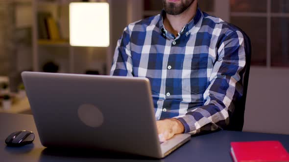 Male Freelancer Typing on Laptop During Night Hours