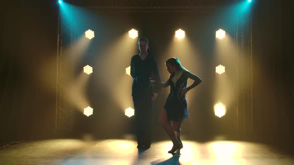 Young Couple Passionately Dancing Rumba and Moving in the Studio with Yellow Spotlights