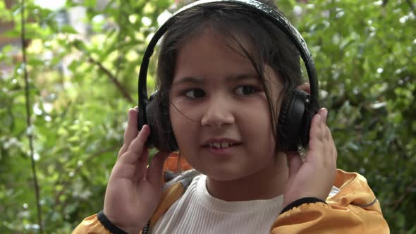 Cute Little Girl Listening To Music With Headphones On A Rainy Day And Dancing 2