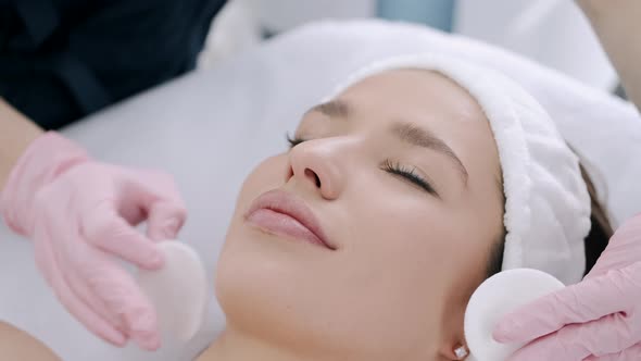 Cropped View of Cosmetologist Cleansing Woman's Skin with Pads
