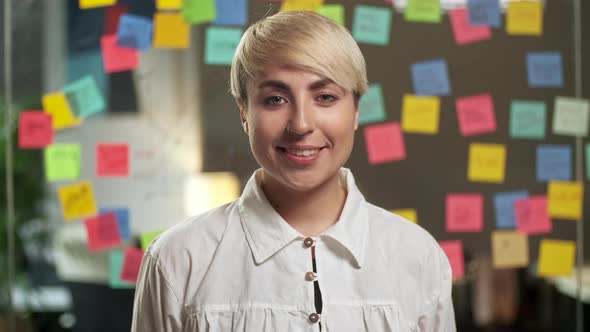 Portrait of Beautiful Young Woman with Blond Hair Wearing Yellow Sweater Looking Up To the Camera