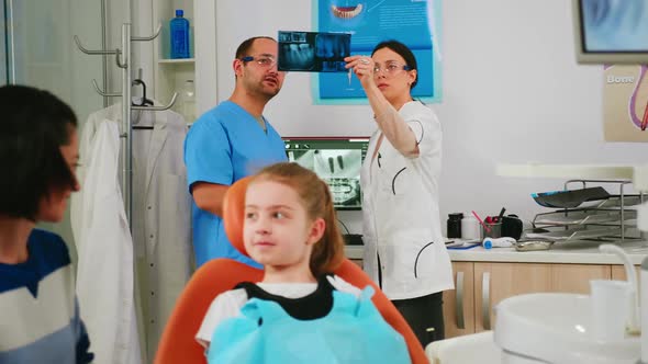 Team of Stomatologist Doctors Analysing Teeth Xray of Little Patient