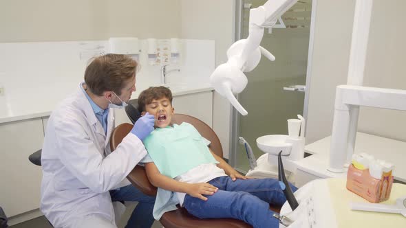 Happy Little Boy High Fiving His Dentist After Successful Dental Examination