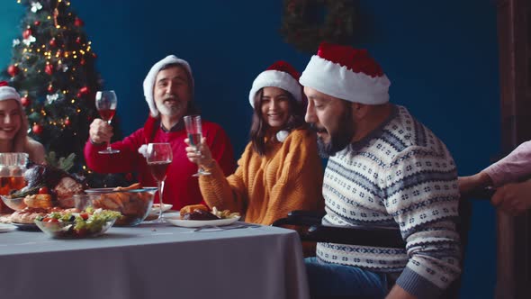 Cheerful Man Wheelchair Drives Up To Family Table Happy Family Clink Glasses Wine Against Background