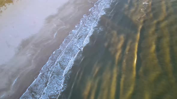 Aerial view of rolling waves and sunrise at the ocean close to Løkken by the North Sea, Denmark