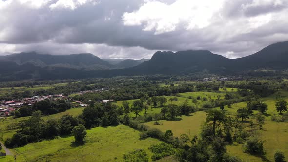 Cinematic aerial footage orbiting and revealing Arenal volcano and Cerro chato in background with he