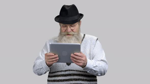 Old Aged Retired Man Playing Racing Game on His Tablet Pc