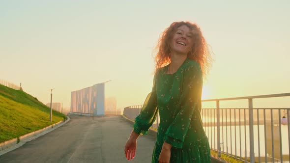 Portrait of Woman Pretty Caucasian Woman with Long Hair Smiling in the City at Sunrise.