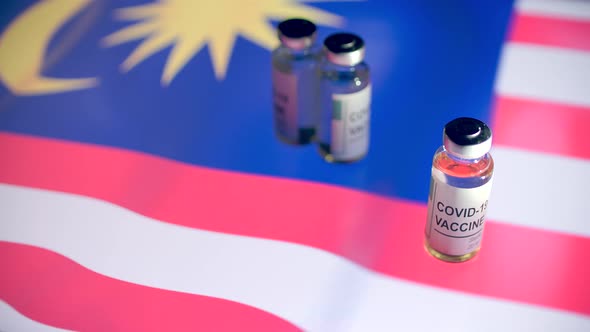 Vials with COVID19 Vaccine and Flag of Malaysia