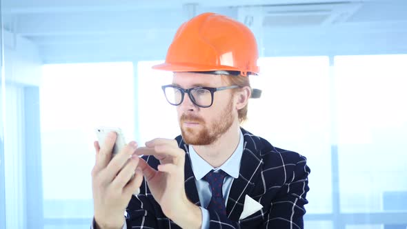 Architectural Engineer Using Smartphone, Browsing online at Work