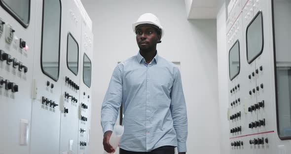 Portrait of an Engineer in a Hard Hat at the Production Blueprint in Hands