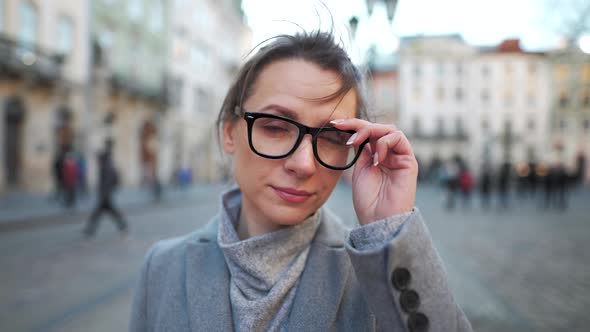 Portrait of a Caucasian Woman in a Coat in the Middle of the Old City Square