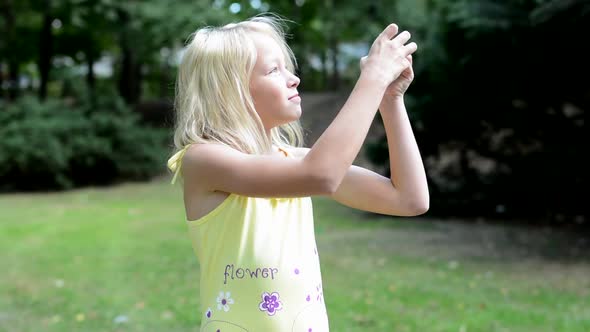 Little Smiling Girl Takes Photos of Nature - She Looking Around Herself and Looks for the New Shoots