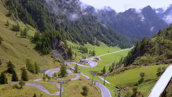 Winding road goes up the mountain at the Dolomite park in northern Italy with cable cars visible goi