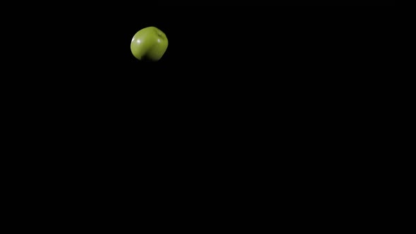 Close Up at Ripe Green Apple Flies Up and Spinning on a Black Background in Slow Motion Shot Vivid