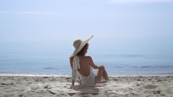 Tempting Woman Sitting Beach Wearing Swimsuit in Front Beautiful Ocean Waves