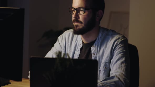 Young Adult Entrepreneur Working on Laptop Computer at Night