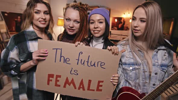 Female Rock Band Holding Feminist Sign