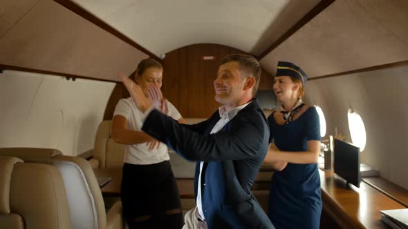 Businesspeople and Stewardess Dancing Inside of Aircraft First Class