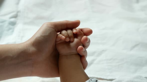 Parent Hands Holding Newborn Baby Fingers