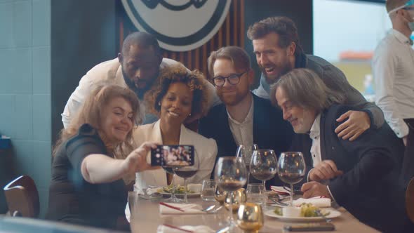 Happy Diverse Friends Having Dinner and Taking Selfie on Smartphone at Restaurant