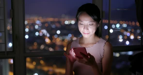 Woman working on cellphone at night 