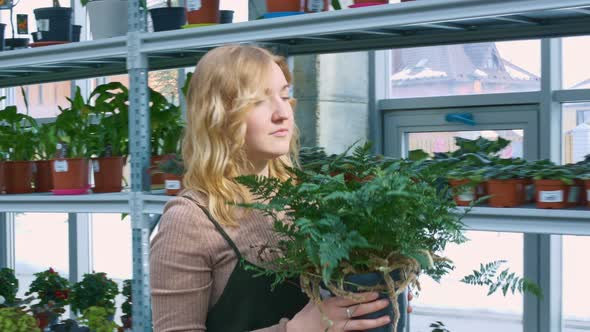 A Young Woman Florist Walks Through the Botanical Garden