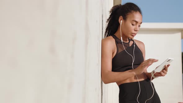 A beautiful american woman with earphones listening the music